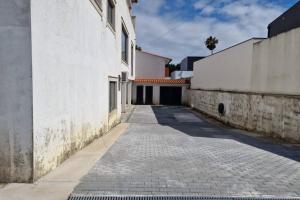 un callejón vacío con un edificio blanco y una calle en RealGoios en Esposende
