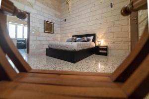 1 dormitorio con 1 cama en una pared de ladrillo en Il colore del Salento, en Carpignano Salentino