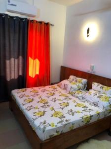 um quarto com uma cama e uma cortina vermelha em Résidence Lotus em Cotonou