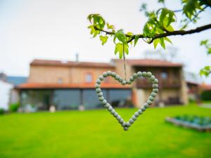 a heart made out of beads hanging from a tree at La Ermita de Deva in Deva