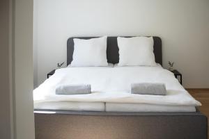 un letto bianco con lenzuola e cuscini bianchi di Elmi 22 a Wals-Siezenheim