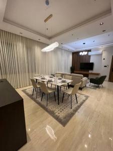 comedor con mesa, sillas y sofá en وجا هوستلز A101 دار الصفاء 47, en Riad