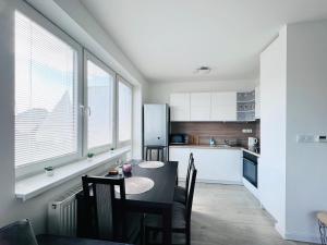 a kitchen with a table and chairs and a refrigerator at City center apartment with nice balcony in Žilina
