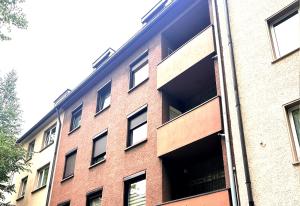 un edificio de ladrillo rojo con muchas ventanas en # VAZ Apartments E01 Küche, TV, Netflix, ca 15 Min Messe u HBf, en Essen