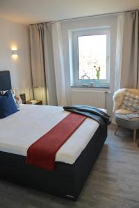 1 dormitorio con cama, ventana y silla en Living Concept Bogenhausen, en Múnich