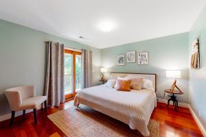 a bedroom with a bed and a chair and a window at Emerald Acres in McKinleyville