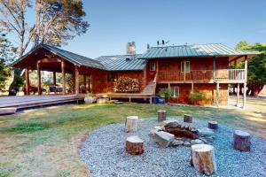 a log house with a fire pit in front of it at Emerald Acres in McKinleyville