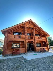 a log cabin with two benches in front of it at Casa Ilies in Rozavlea