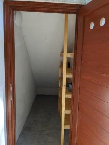 een zolderkamer met een ladder en een kast bij Apartmaji Klanc in Bovec