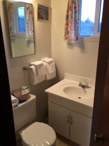 bagno con lavandino, servizi igienici e specchio di Chris by the Sea Motel a Ocean Shores