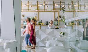 Un gruppo di donne che si trovano davanti a un bar di Ivi Mare - Designed for Adults by Louis Hotels a Paphos
