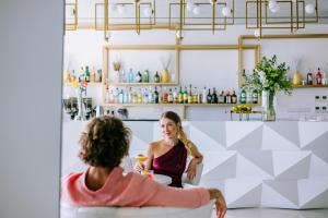 two women sitting at a table in a kitchen at Ivi Mare - Designed for Adults by Louis Hotels in Paphos