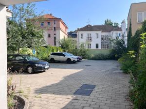 dos coches estacionados en un estacionamiento con edificios en City center apartment with nice balcony, en Žilina