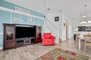 a living room with a television and a red chair at The Lighthouse in Panama City Beach