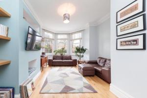 a living room with a couch and a tv at Bright & spacious modern 2 bedroom apartment in London