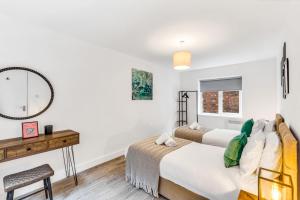 1 Schlafzimmer mit 2 Betten und einem Spiegel in der Unterkunft We Stay Baxter Gate 2 Bedroom Duplex Apartment in Loughborough