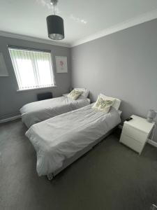 a bedroom with two beds and a window at Newly Refurbished Apartment with private parking in Southampton