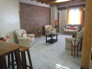 a living room with couches and a brick wall at Cabañas Solares del Villicum in Albardón