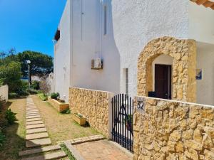 a building with a stone wall and a fence at REFÚGIO DO CARANGUEJO - Praia da Luz - WiFi, Private Pool & BBQ in Luz