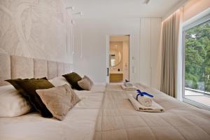 a large white bed in a room with a window at Villa Bursztyn BlueApart Jurata in Jurata