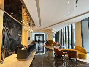 a lobby of a building with chairs and tables at Crystal Suites at Axon Residence near Pavilion in Kuala Lumpur