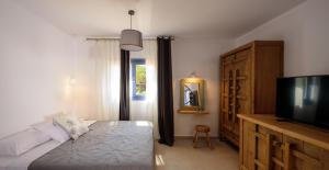 a bedroom with a bed and a flat screen tv at White Dream Suites Antiparos in Antiparos