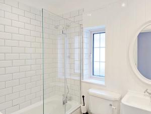 a bathroom with a shower and a toilet and a sink at Grace Cottage - Emsworth in Emsworth +30 photos