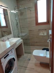 a bathroom with a toilet and a washing machine at Athor Ireon Apartment 1 in Ireon +27 photos