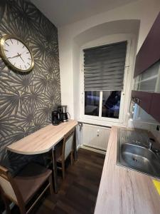 a kitchen with a sink and a clock on a wall at Elias 1 und 3 in Erfurt