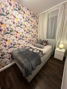 a bedroom with a flowery wallpaper on the wall at Elias 1 und 3 in Erfurt