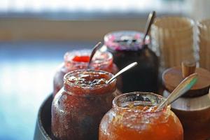 a group of jars of honey with spoons in them at Hôtel Maora Village in Bonifacio