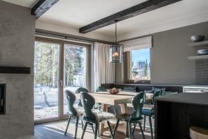 卡其貝格霍赫的住宿－KAUZ - Design Chalets inkl Lungau Card，一间带桌子和绿色椅子的用餐室