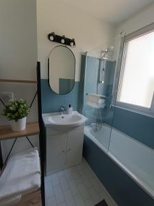 La salle de bains est pourvue d'un lavabo, d'une baignoire et d'un miroir. dans l'établissement Les reflets, à Dijon