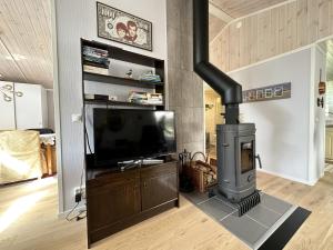 a living room with a fireplace and a tv at Mysig stuga med villastandard i Tanumshede in Tanumshede