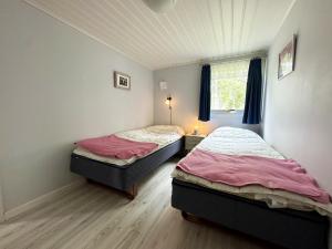 two twin beds in a room with a window at Mysig stuga med villastandard i Tanumshede in Tanumshede