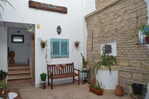 a patio with a bench and a brick wall at Apartamentos El Aljibe Relax Tourist Cordoba in Córdoba