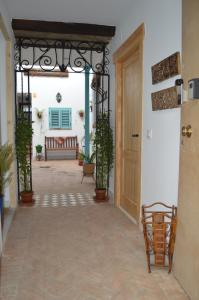 un corridoio di una casa con porta e piante in vaso di Apartamentos El Aljibe Relax Tourist Cordoba a Cordoba