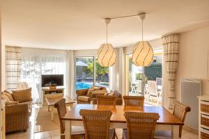 uma sala de estar com uma mesa de jantar e cadeiras em Oasis Les Jardins des Sables d'Olonne em Les Sables-dʼOlonne