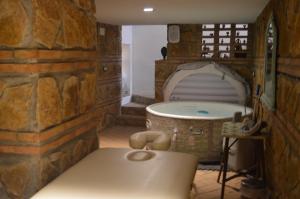 a bathroom with a tub in a stone wall at Apartamentos El Aljibe Relax Tourist Cordoba in Córdoba