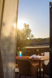 a table with a book and a glass of wine at White Dream Suites Antiparos in Antiparos