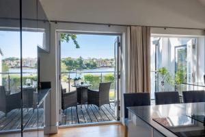 a living room with a balcony with a table and chairs at Harbour View in Lymington