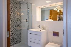a white bathroom with a sink and a shower at Harbour View in Lymington +44 photos