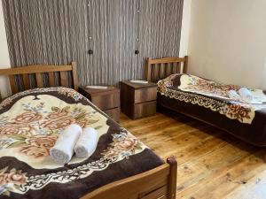 twee bedden in een kamer met houten vloeren bij lileo in Omalo