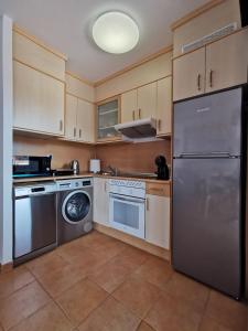 una cucina con frigorifero in acciaio inox e lavastoviglie di Casa Fuerte Aventura a Lajares