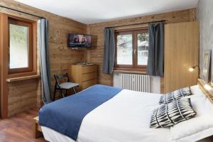 a bedroom with a bed and a chair and windows at HelloChalet - Chez León in Valtournenche