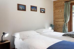 a bedroom with a white bed with two pictures on the wall at HelloChalet - Chez León in Valtournenche