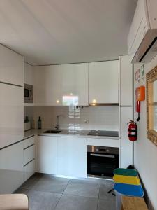 a kitchen with white cabinets and a blue chair at Casa Sousa Alojamento A1 in Boticas +14 photos