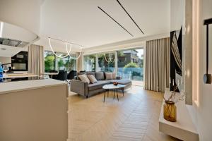 a kitchen and living room with a couch and a table at Villa Bursztyn BlueApart Jurata in Jurata