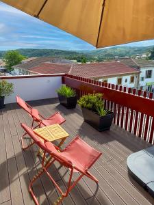 two chairs and a table on a deck with an umbrella at Casa Sousa 3rd generation - Apart 1 in Boticas