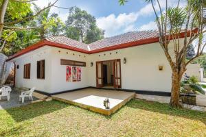 康提的住宿－Bopegedara Comfort Villa - Kandy，院子中一棵树的小白色房子